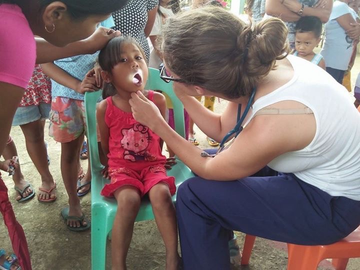 An MSIH student examining a girl in the Philippines 